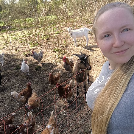 Claudia Minzlaff mit ihren Hühnern im Hintergrund
