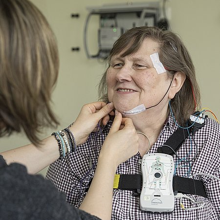 DIAKO Medizinerin bringt Gerat zu Schlafkontrolle an Patientin an | Schlaflabor